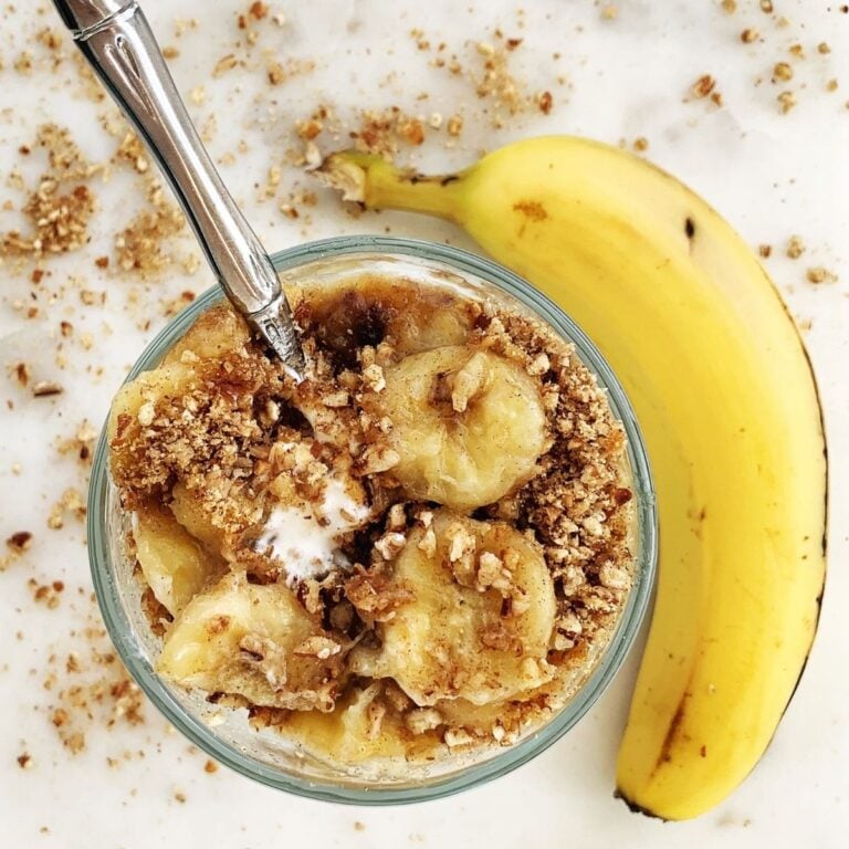 Overhead shot of a Greek Yogurt Parfait topped with bananas foster, nuts, and flaxmeal.