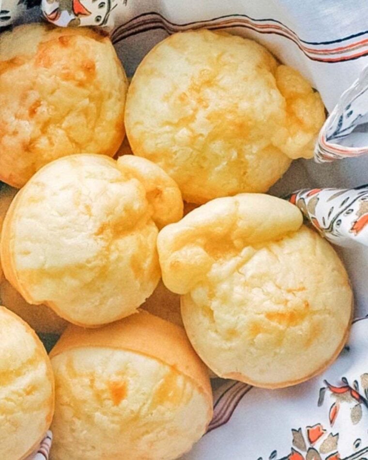 Brazilian Cheese Bread Rolls nestled in a white and orange towel.