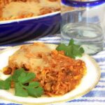 Square photo with baked pasta on a white plate.