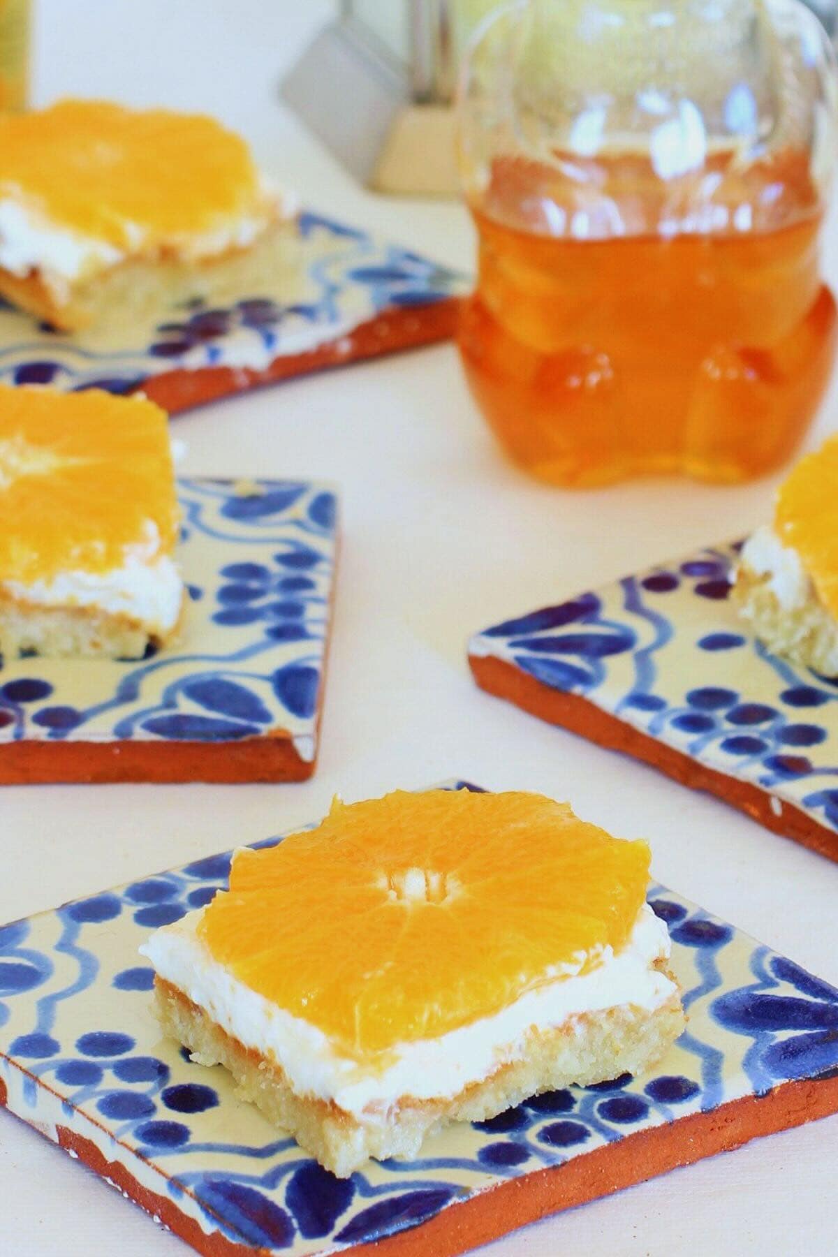 Gluten Free Orange Honey Cheesecake Bars on a blue and white tile background.