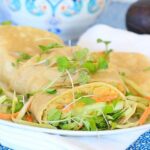 White plate piled with Chickpeas Avocado Salad Smash wraps.