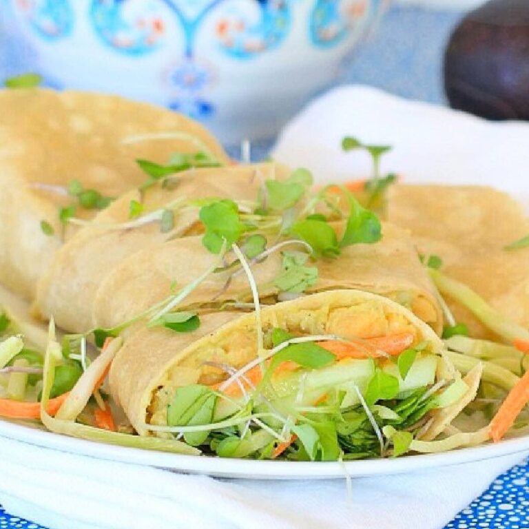 White plate piled with Chickpeas Avocado Salad Smash wraps.