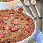 Baked oatmeal Chia pie in a white tart pan with strawberries on top.