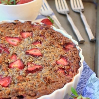 Baked oatmeal Chia pie in a white tart pan with strawberries on top.