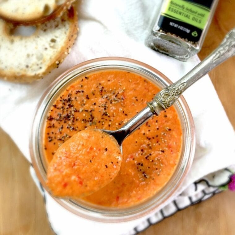 OVerhead photo of yellow gazpacho in a mason jar. Spoon on top.