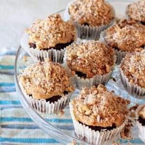 Gluten free German chocolate cupcakes on a glass cake tay.