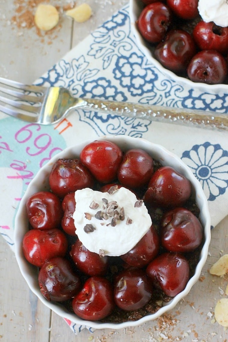 vegan cherry pie in a white mini tart dish with whipped cream on top