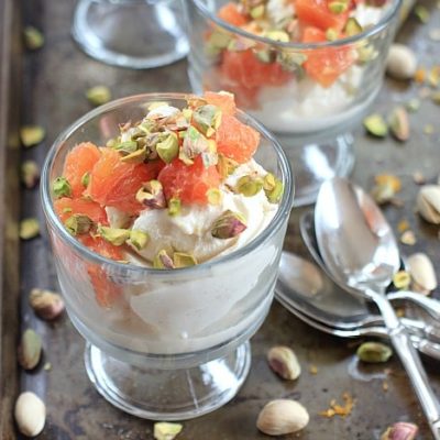 Orange Cardamom Pistachio Ice Cream Sundae is a glass dish with a serving spoon