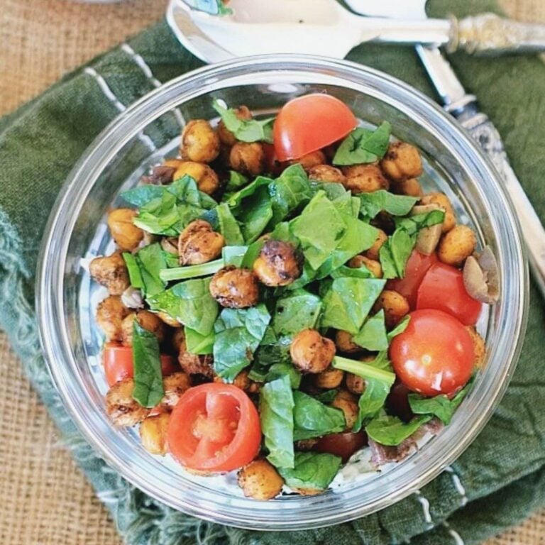 Savory yogurt bowl topped with crispy chickpeas, spinach, and tomatoes.