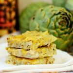 Three artichoke squares stacked up on a white napkin.