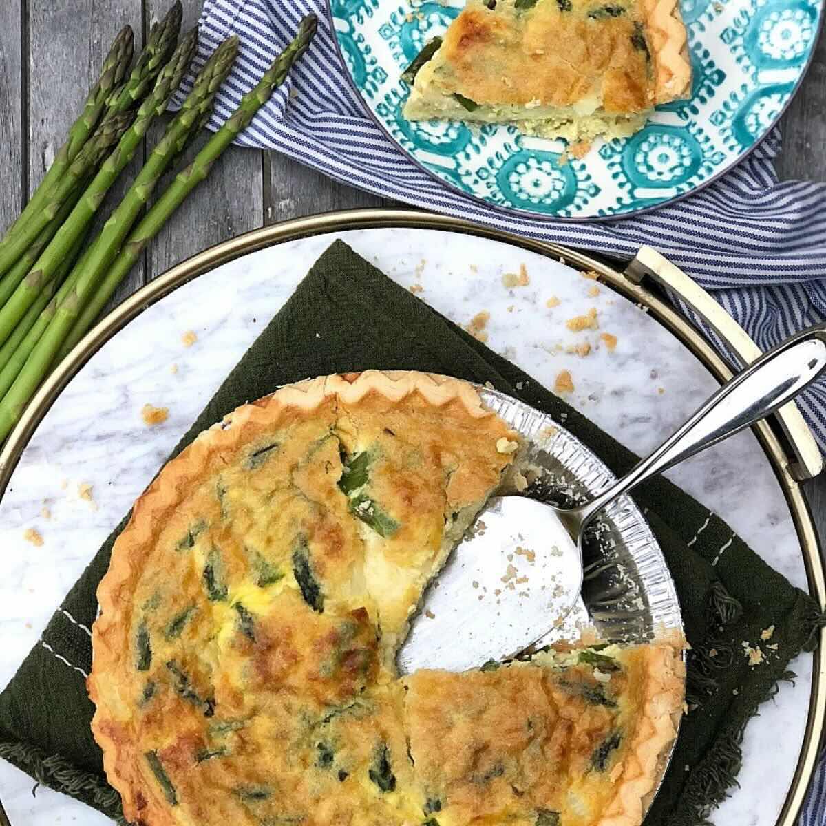 Overhead photo of gluten free asparagus quiche with asparagus in the background.