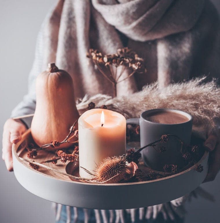 Candles and hot chocolate on a serving tray.