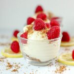 Healthy frozen dessert in a glass bowl featuring lemon ice cream, ginger pecan crumble, and fresh raspberries.