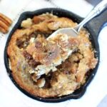 Overhead shot of a vegan pecan pie tart in a mini cast iron skillet.