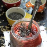 Mason jar with chocolate overnight oats, strawberry sauce, and cacao nibs.