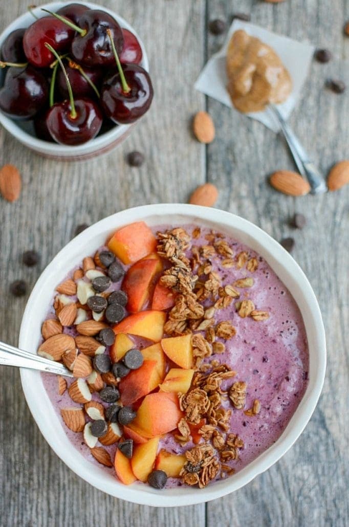 Healthy Smoothie recipes | smoothie bowl topped with peaches, almonds, granola, and chocolate chips