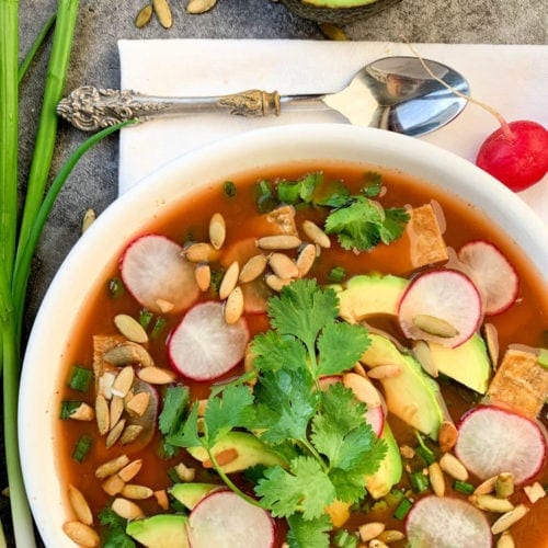 vegan tortilla soup in a white bowl with cilantro and avocado