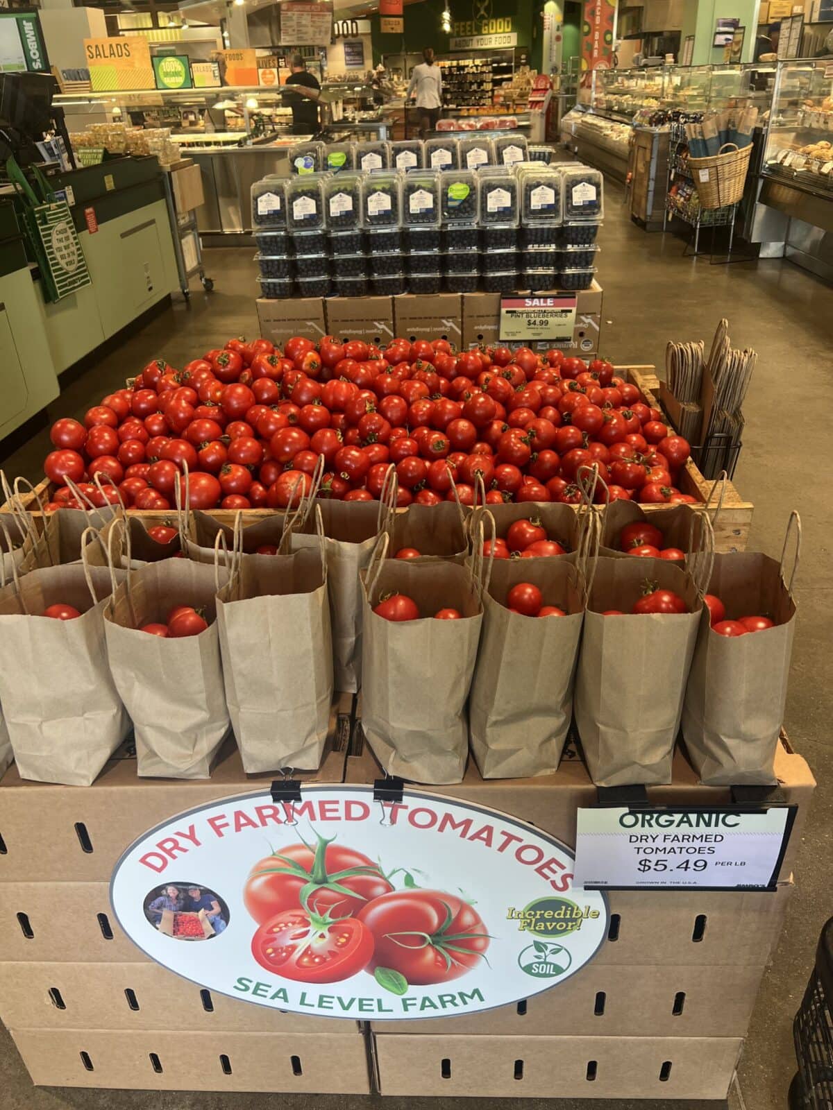 Bags of dry farmed tomatoes on a stand at the grocery store.