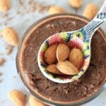 Small bowl of chocolate Almond butter with a teaspoon on top.