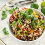 Close up shot of a white bowl filled with quinoa and black bean salad.