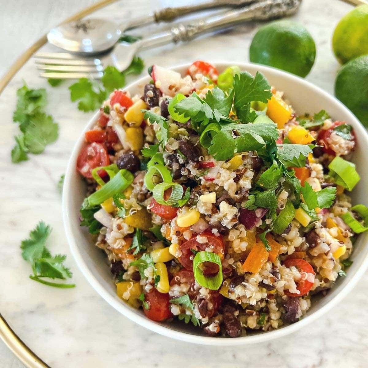Close up shot of a white bowl filled with quinoa and black bean salad.