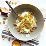 Close up shot of of a cottage cheese breakfast bowl topped with passion fruit and walnuts.