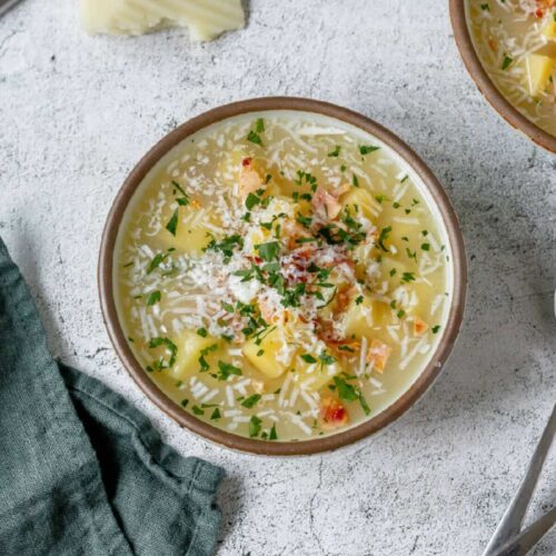 Ceramic bowl with baked potato soup and lots of toppings.
