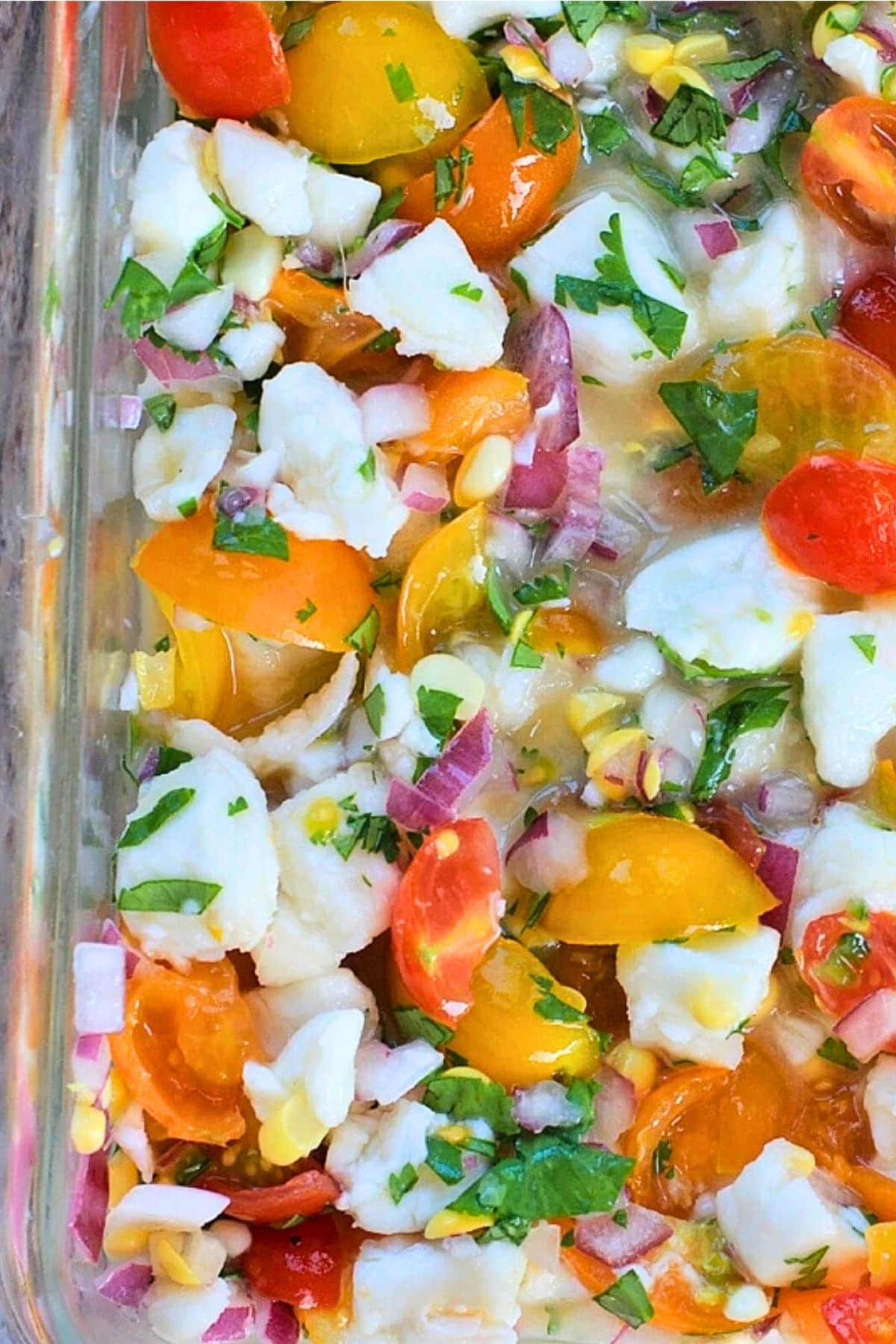 Glass baking dish with ingredients for a halibut ceviche recipe.