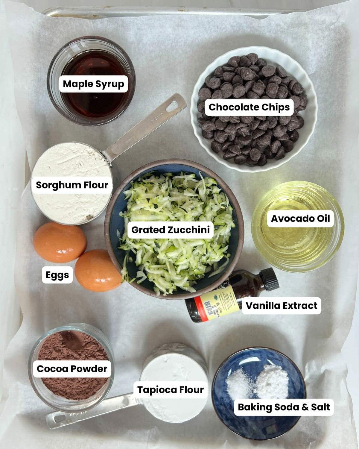 Parchment lined tray with ingredients to make gluten-free zucchini muffins.