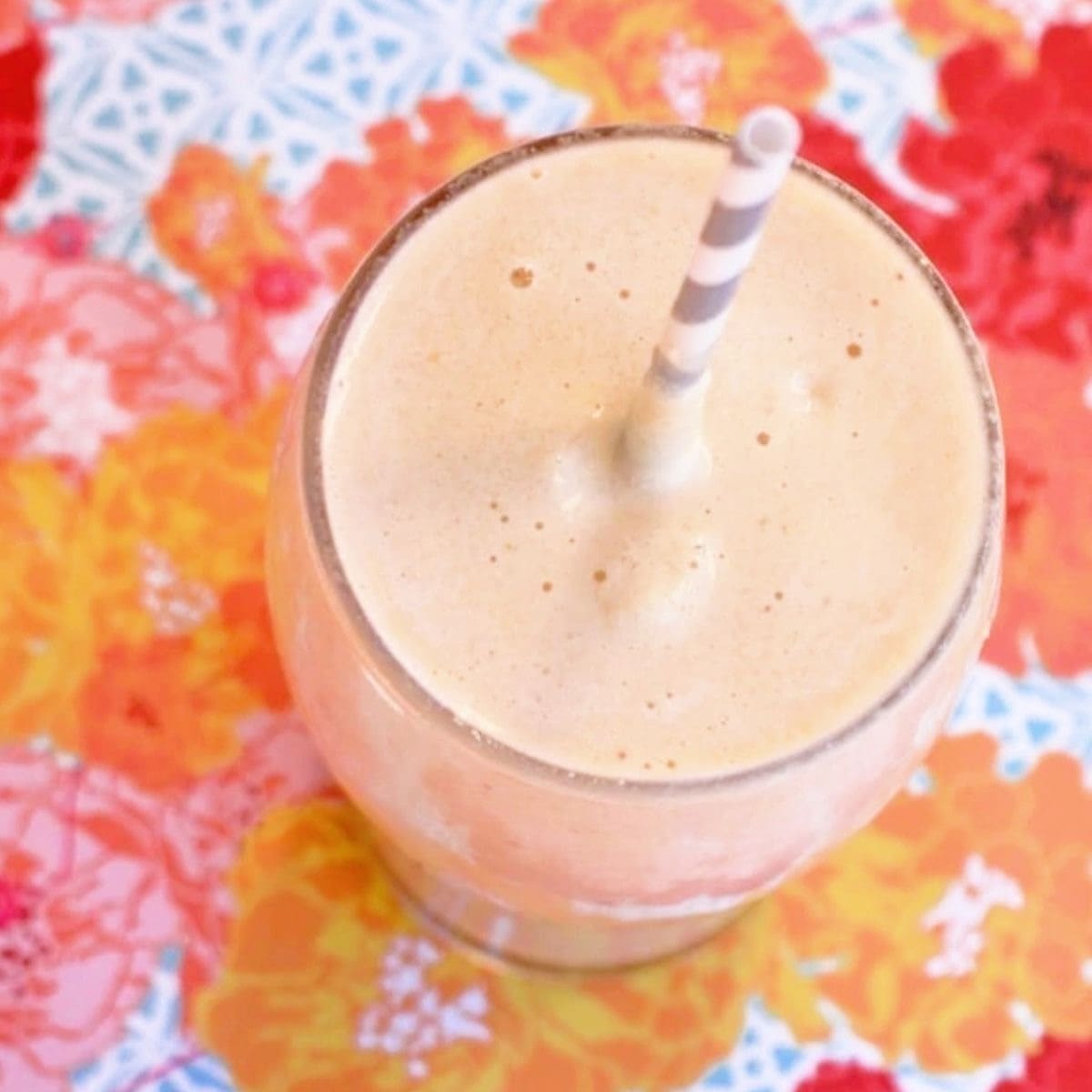 Close up photo of an immune boosting smoothie on a colorful orange and pink background.