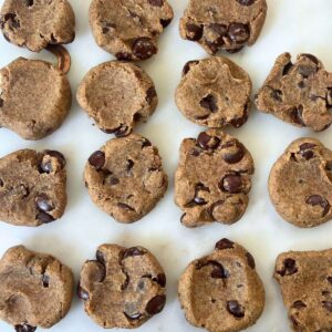 White marble tray covered with chocolate chip chickpea cookies.