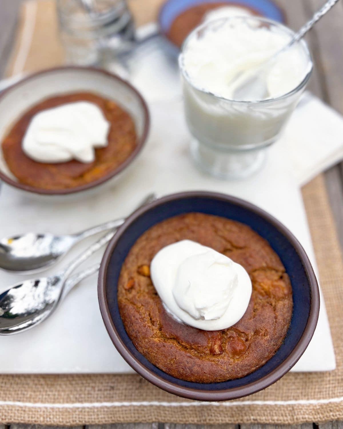Close up shot of dessert topped with whipped cream in a blue bowl.