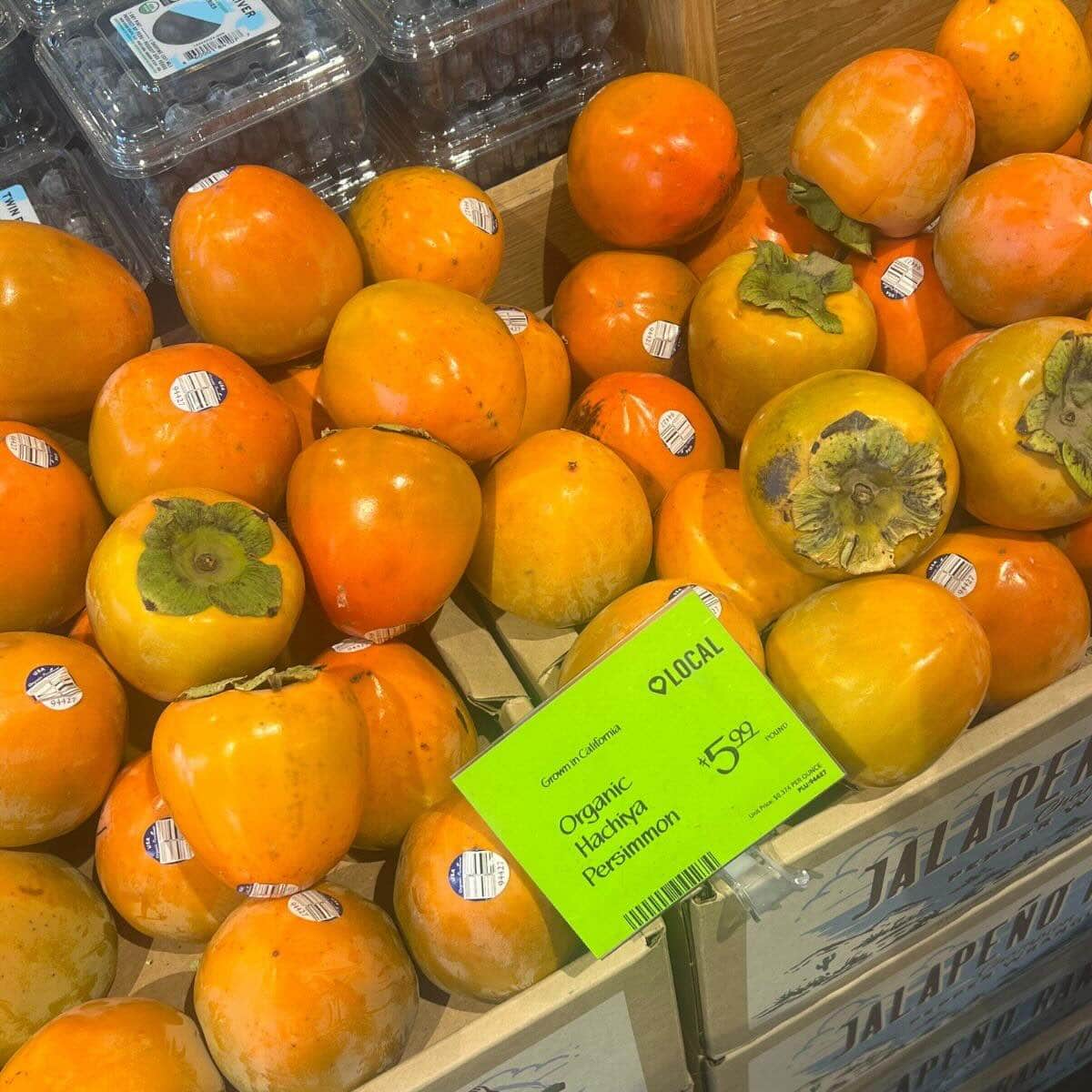 Close up photo of local persimmons on display in the grocery store.