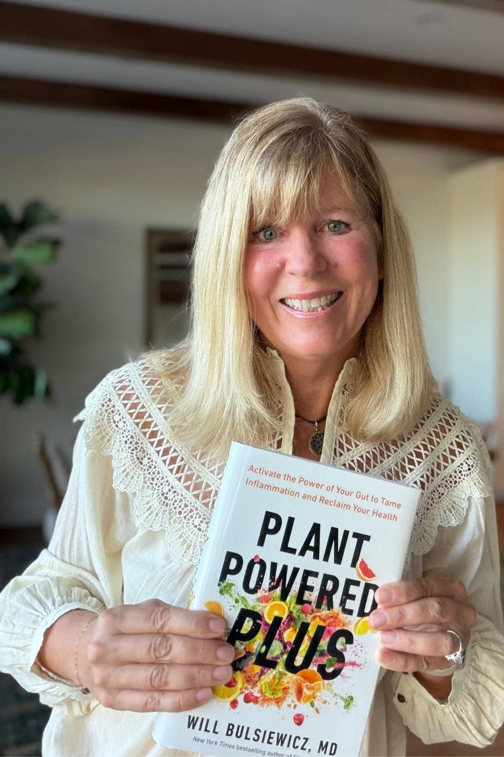 A photo of EA Stewart, RD, holding a copy of Plant Powered Plus.
