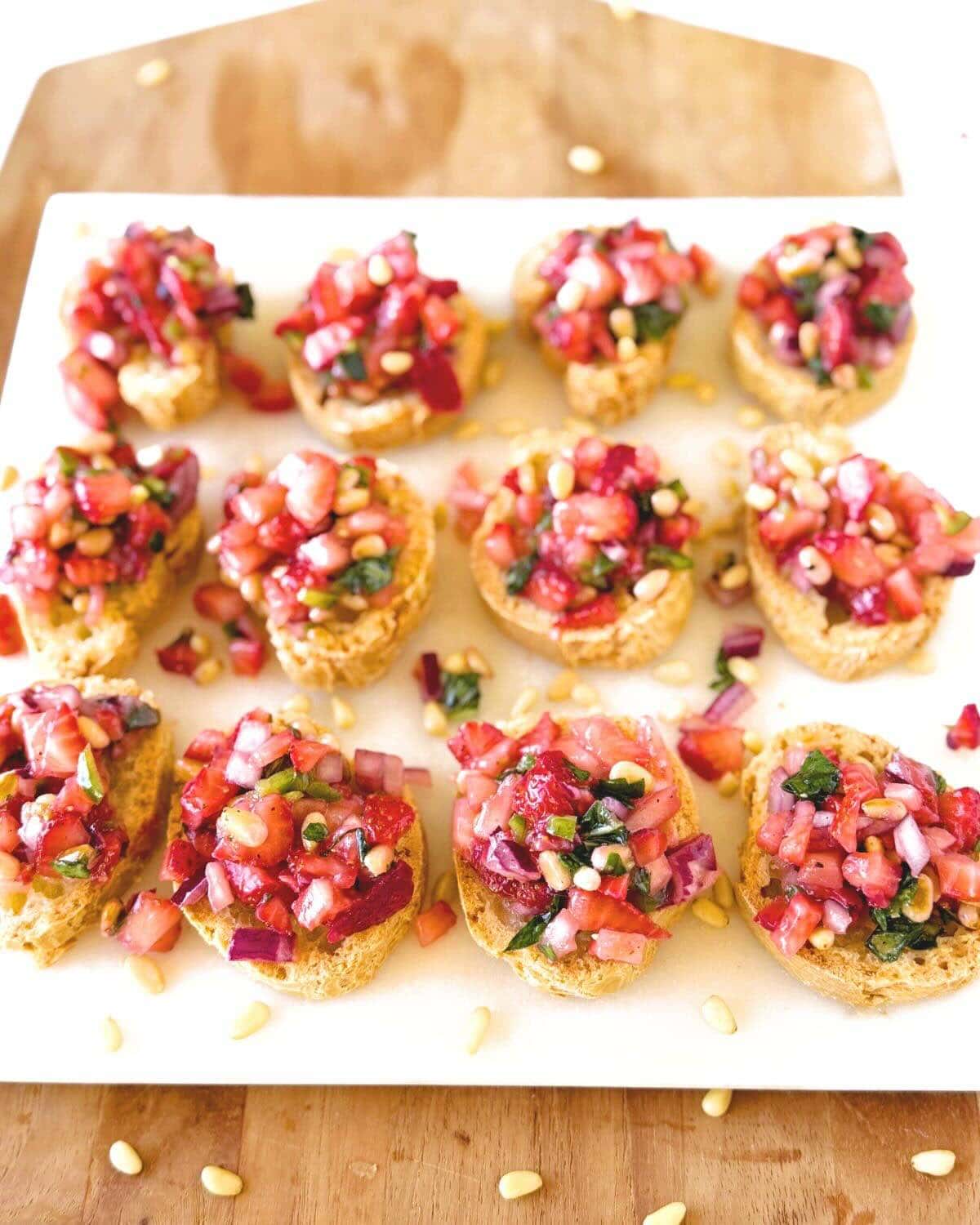 Bruschetta topped with strawberry salsa on a white tray.