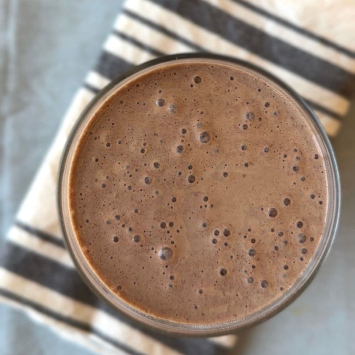Close-up of a frothy chocolate smoothie in a glass.